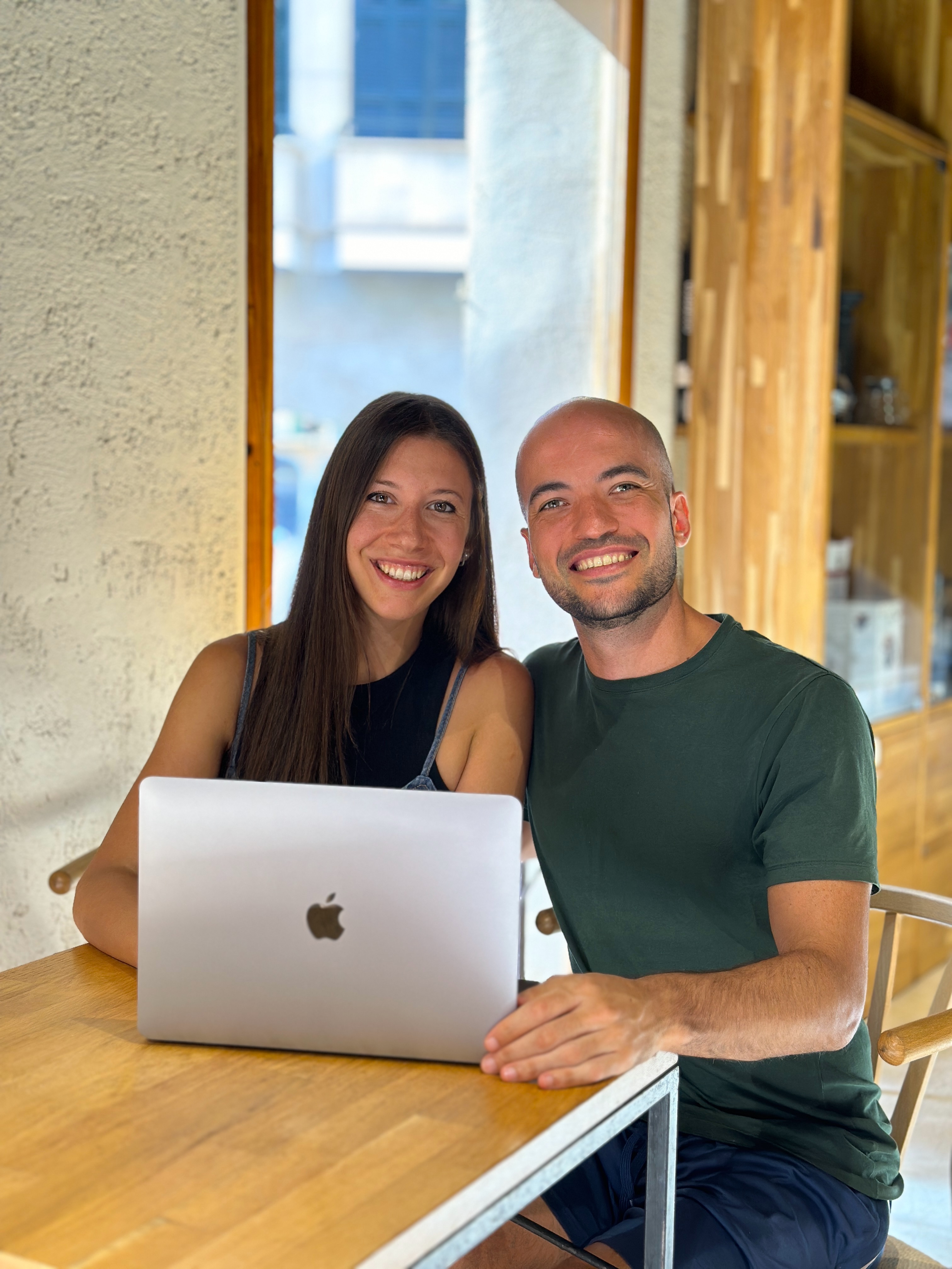 Silvia y Diego sentados trabajando con una laptop